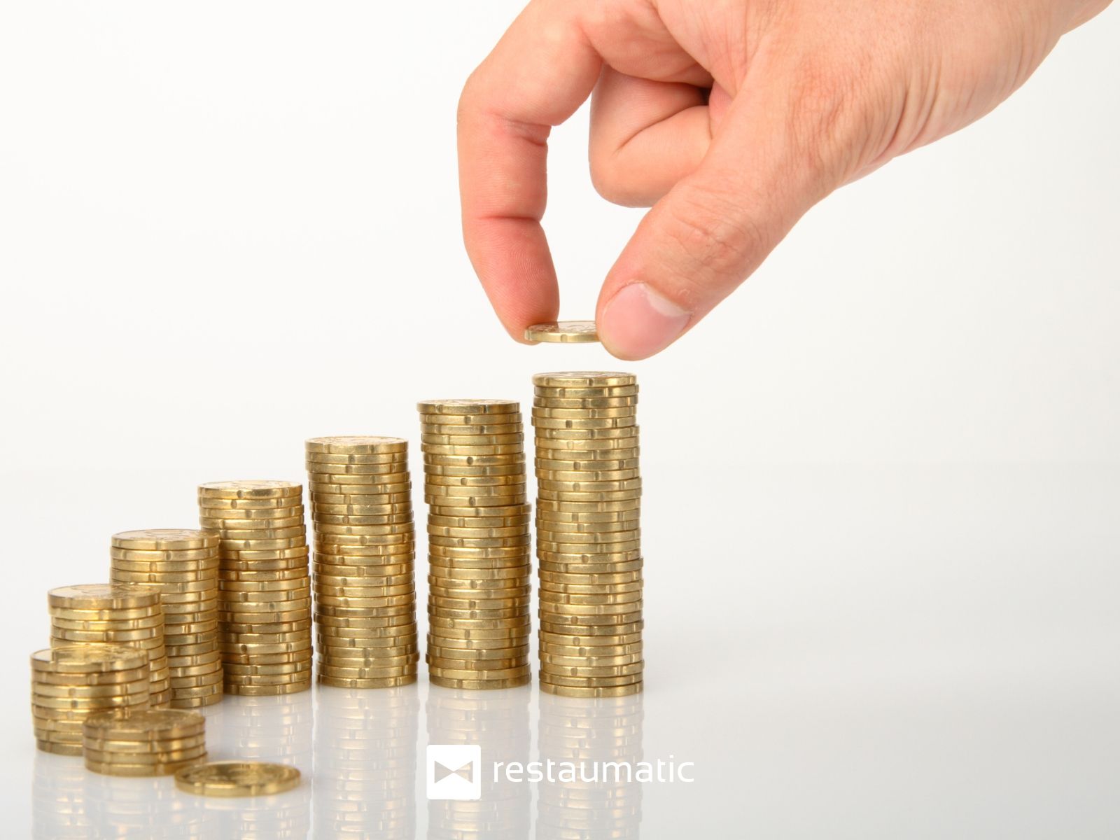 Mężczyzna układa monety w słupki.