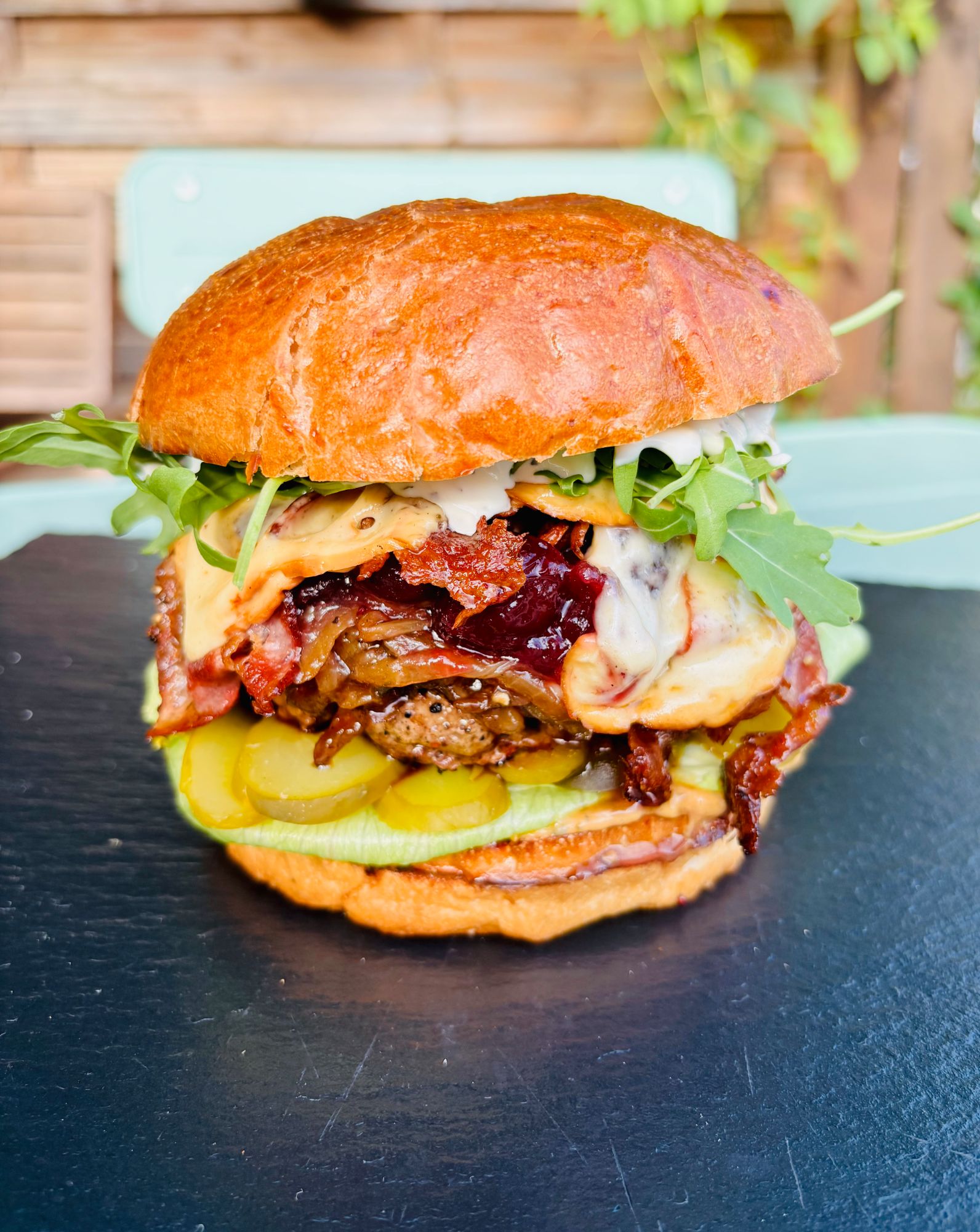 Soczysty burger z mięsem, bekonem, serem, piklami i świeżą sałatą w chrupiącej bułce.