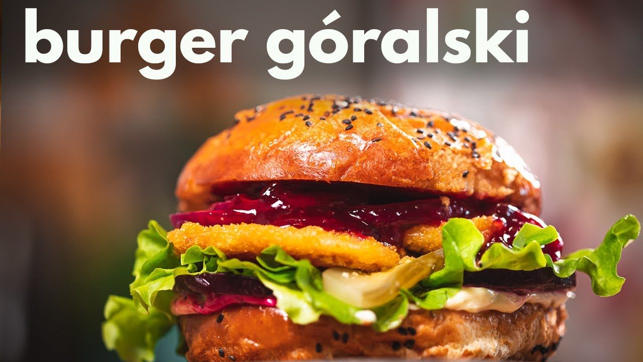 Burger góralski z chrupiącym kotletem, świeżą sałatą, dżemem owocowym i majonezem na sezamowej bułce.