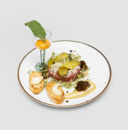 Tatar z cebulką, ogórkiem i grzybkami marynowanymi oraz grzanką z masłem