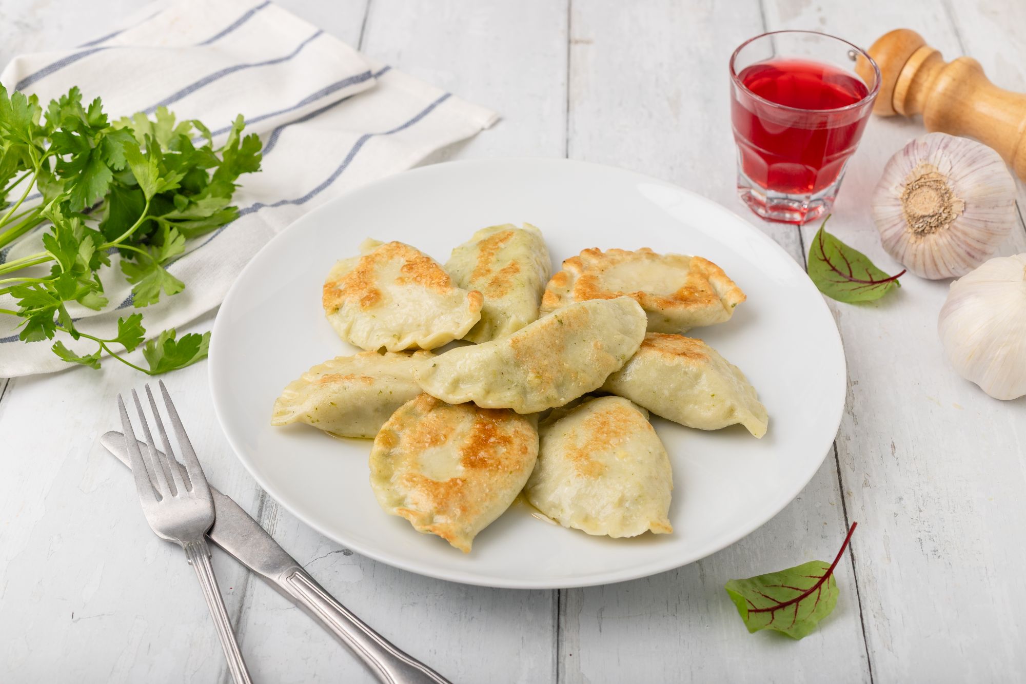 Pierogi ze szpinakiem smażone na maśle z czosnkiem i natką pietruszki 