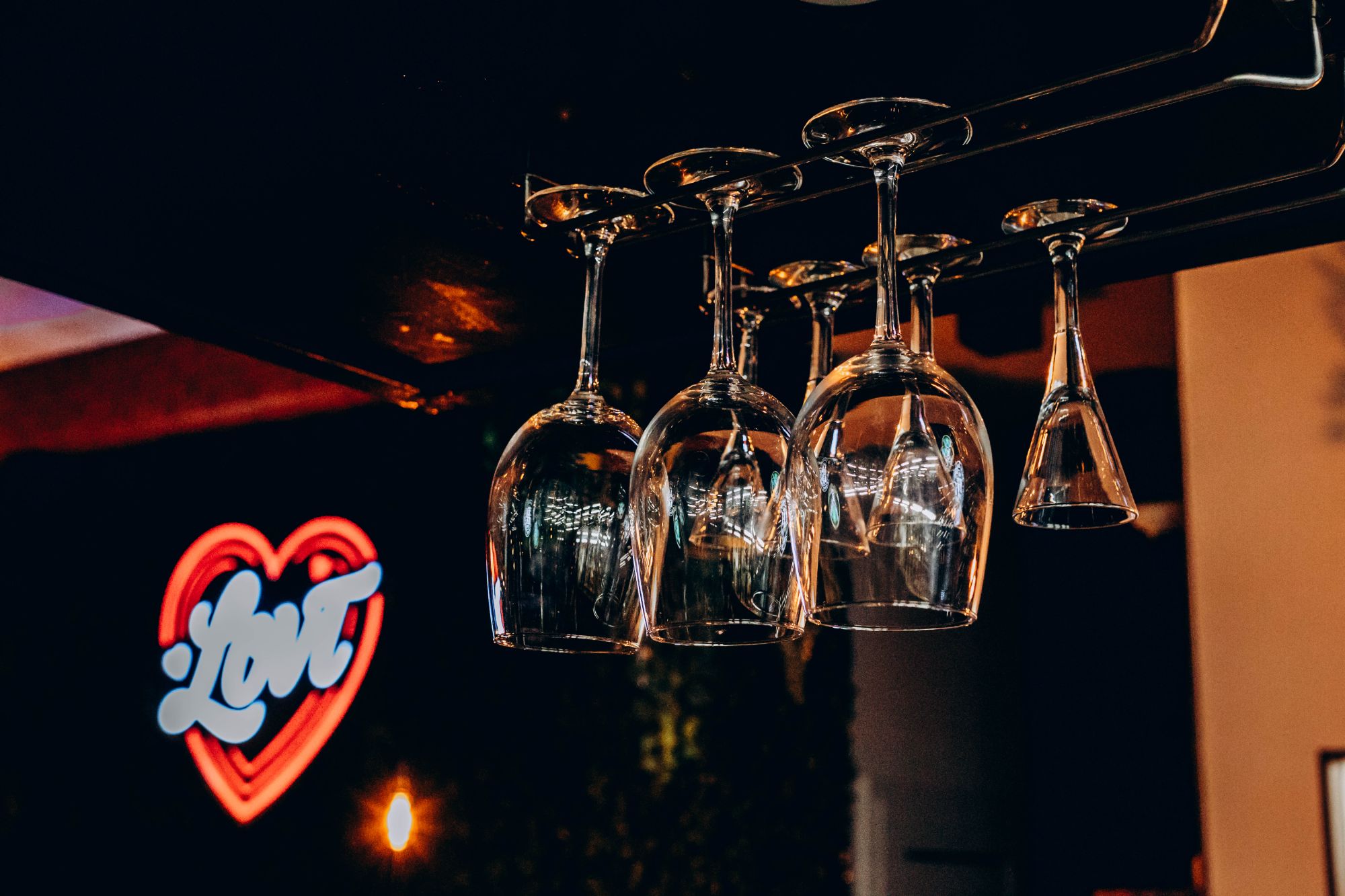 Wiszące kieliszki do wina z tłem neonowego serca "Love".