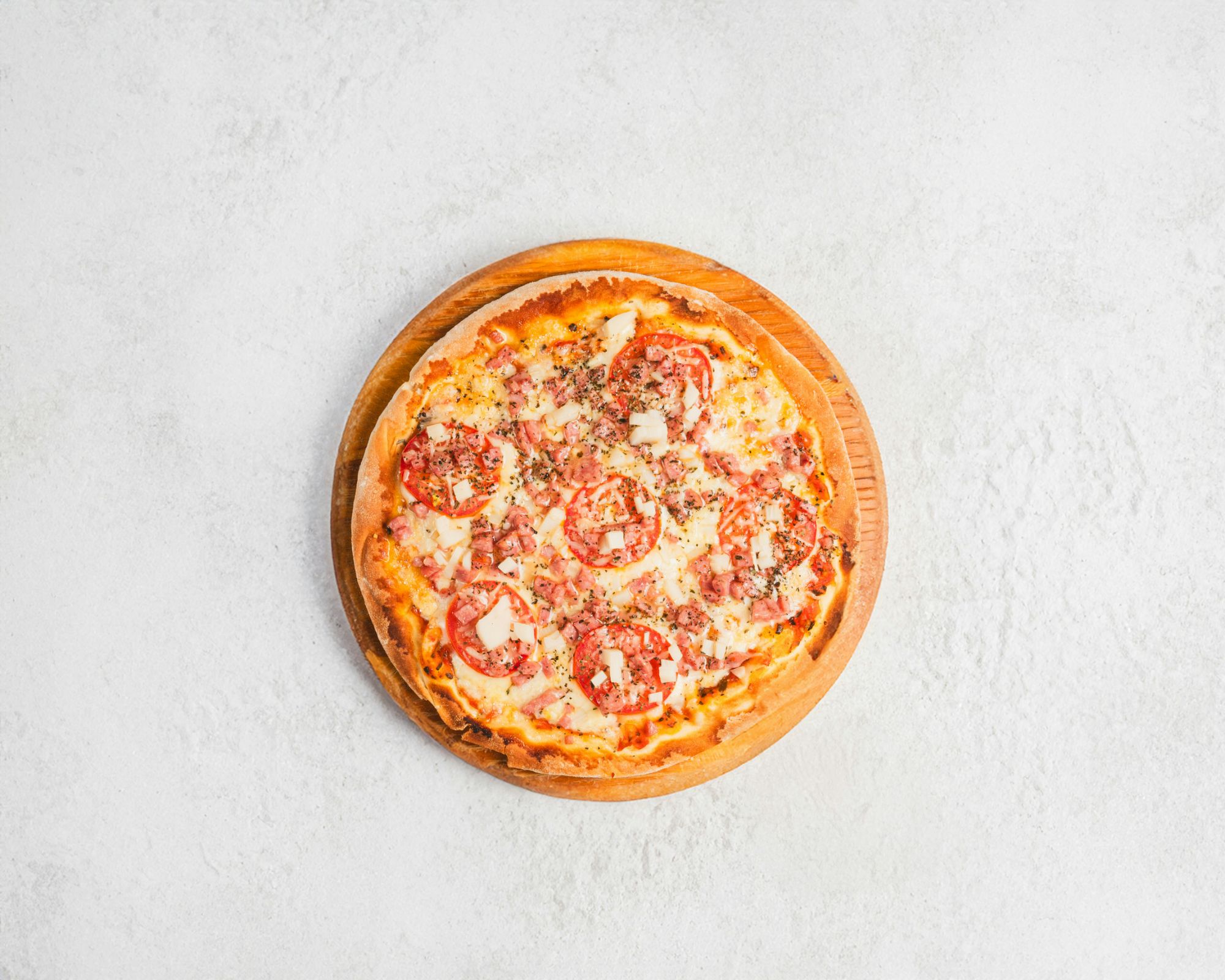 Pizza delicioasă cu roșii, brânză și condimente, servită pe un platou din lemn.