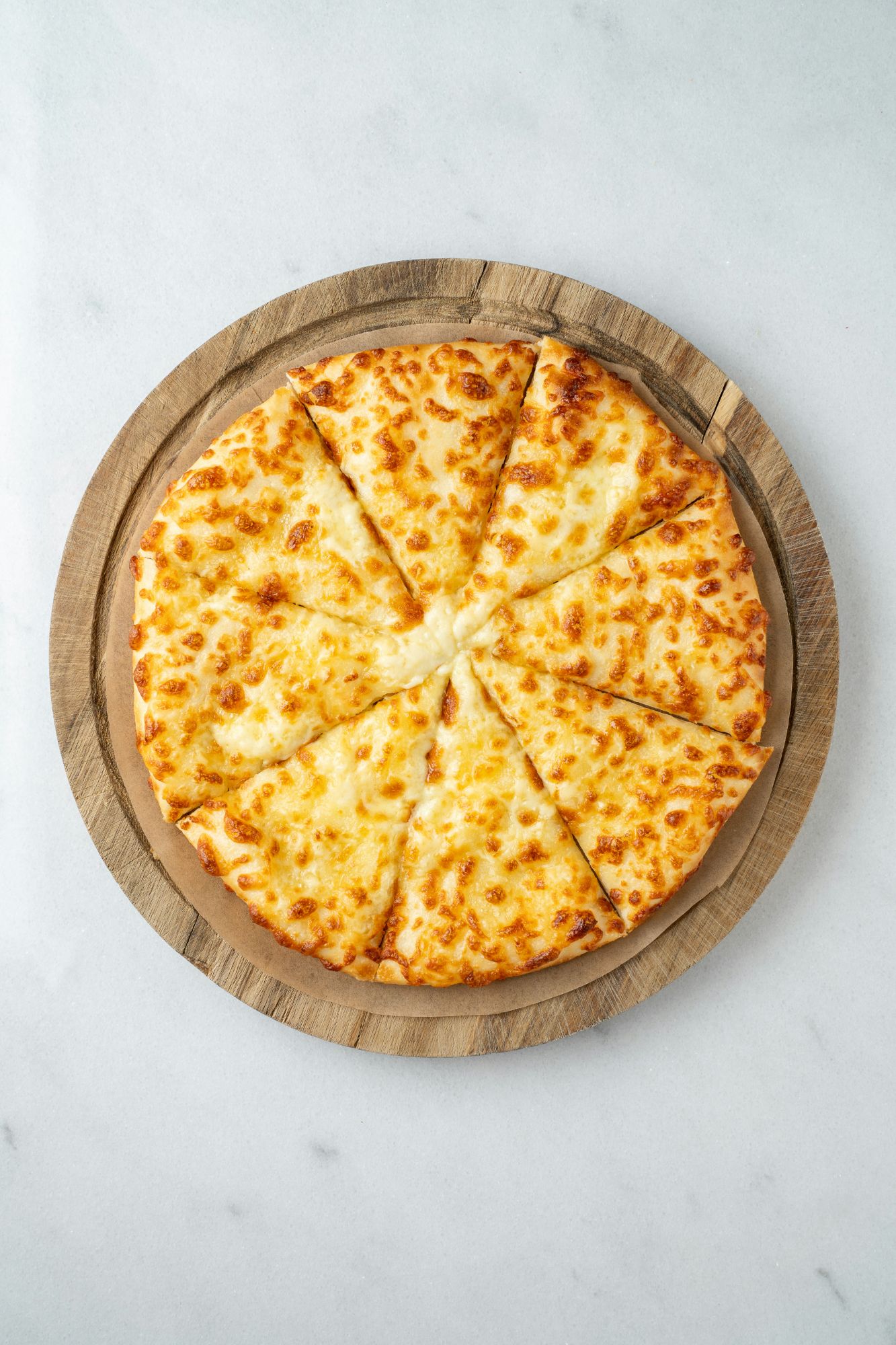 Pizza cu brânză, tăiată în opt felii, servită pe un platou din lemn.
