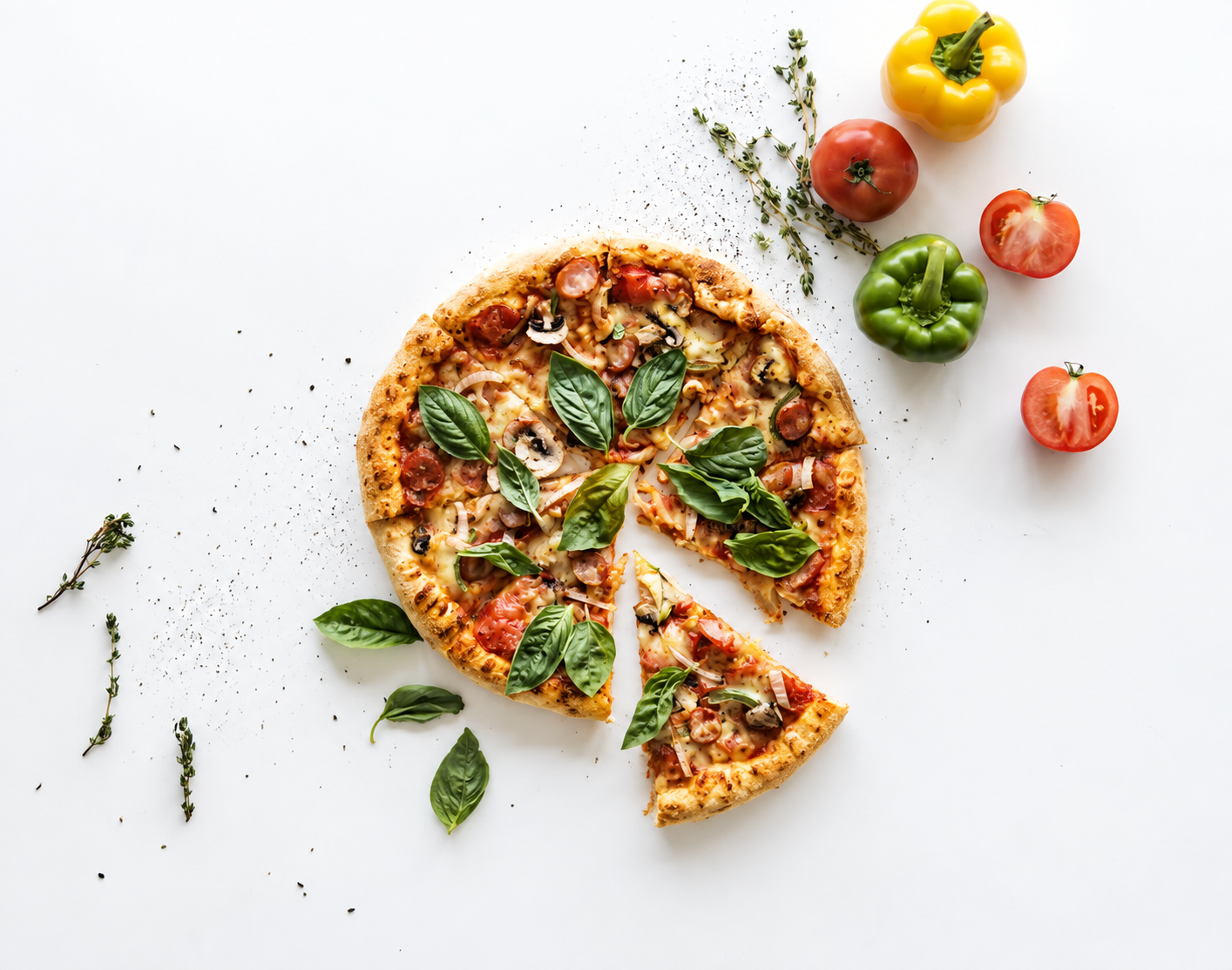 Pizza cu ciuperci, roșii și ierburi proaspete, decorată cu ardei grași pe un fundal alb.