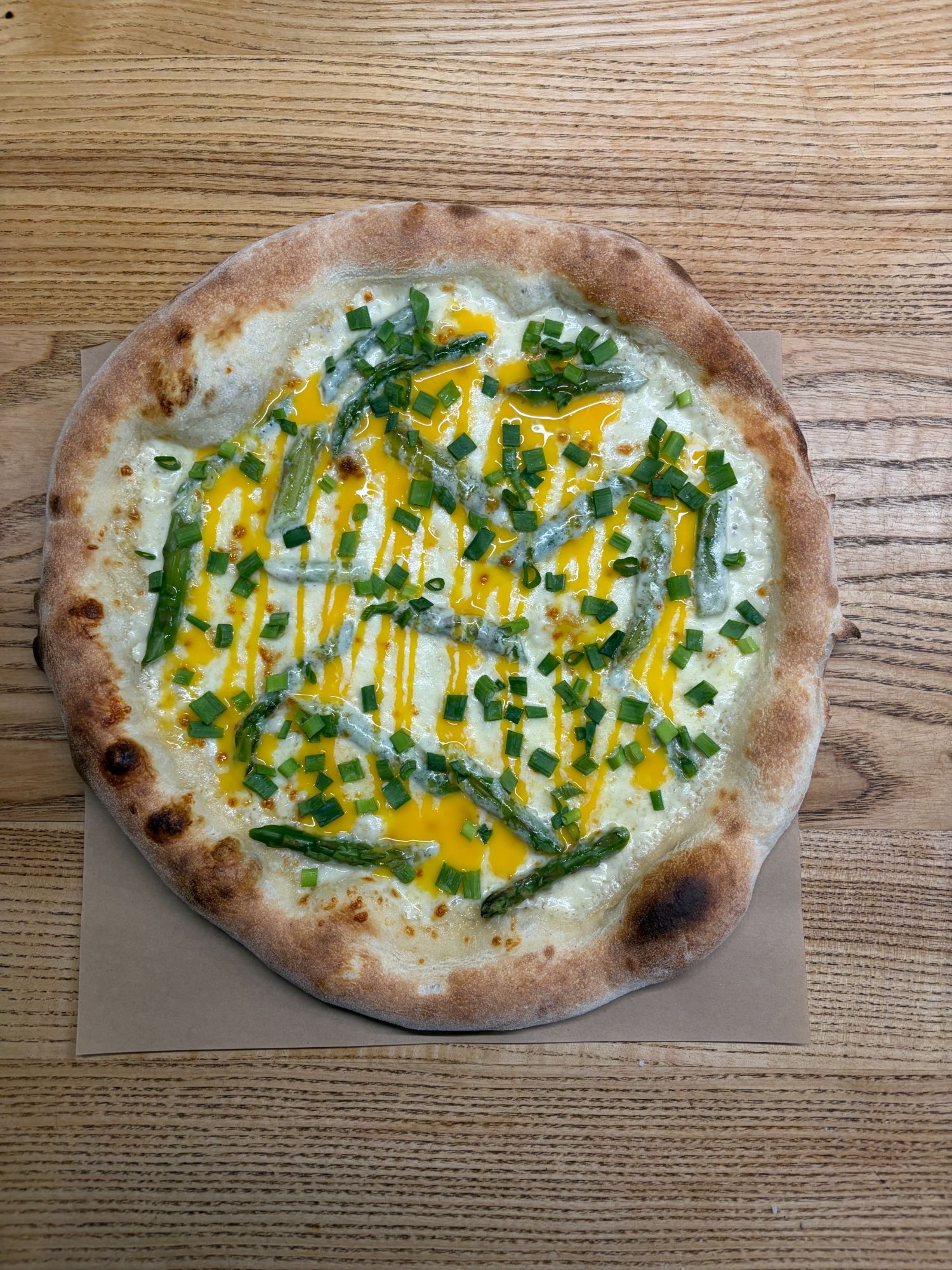 Pizza z zieloną fasolką, cebulą, sosem serowym na cieście z brzegiem z chrupiącego ciasta.