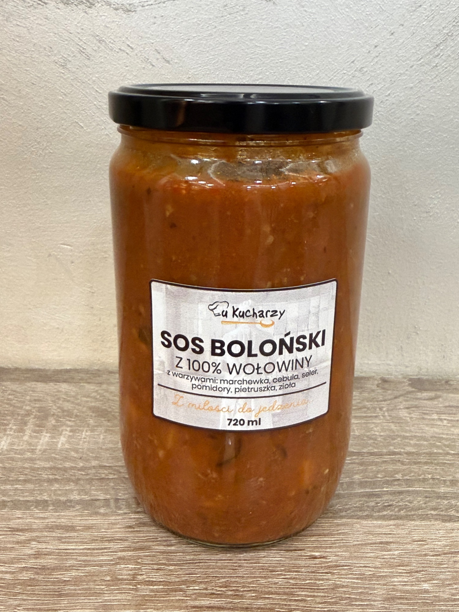 Słoik sosu bolońskiego z 100% wołowiny, 720 ml, etykieta zawierająca składniki i informacje o produkcie.