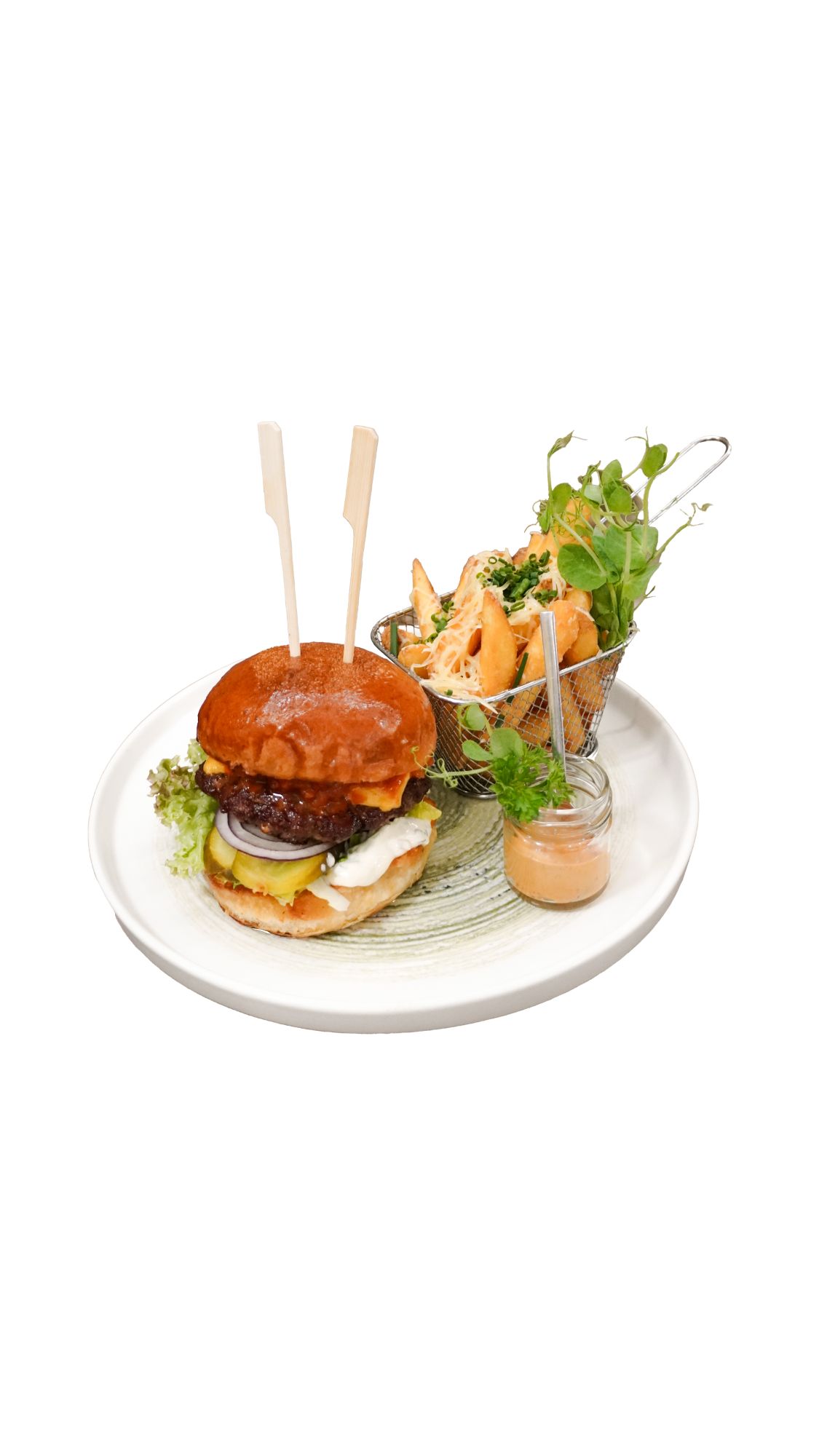 Burger z grillowanym mięsem, świeżymi warzywami, frytkami i sosem na talerzu.