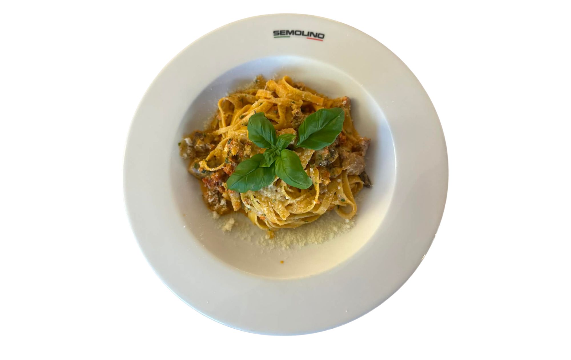 Talerz z makaronem, posypanym serem i bazylią, na białym tle.