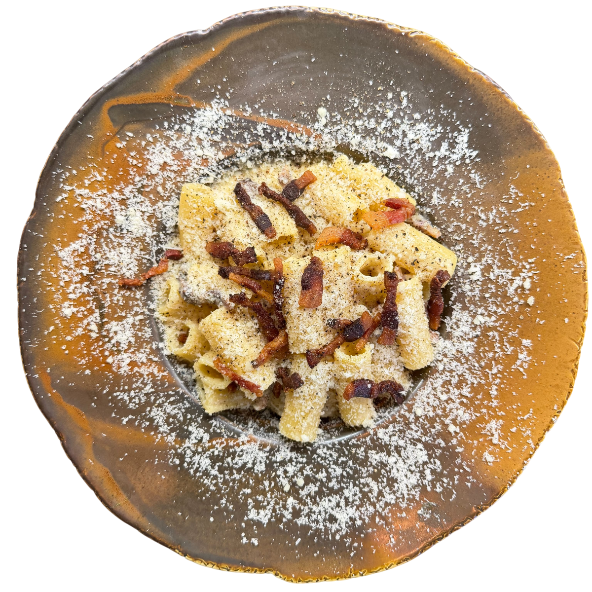 Pasta alla carbonara z rigatoni, chrupiącym guanciale, pecorino i czarnym pieprzem na rustykalnym talerzu