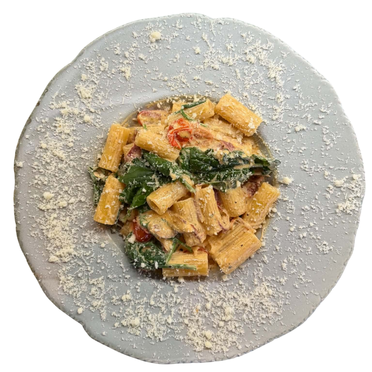 Pikantna kremowa pasta rigatoni ze szpinakiem, papryczką chili i pomidorkami, posypana parmezanem
