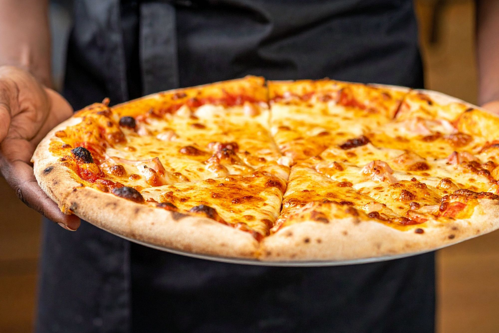Rúra s čerstvou pizzou so syrom a paradajkovou omáčkou, servírovaná na tanieri.