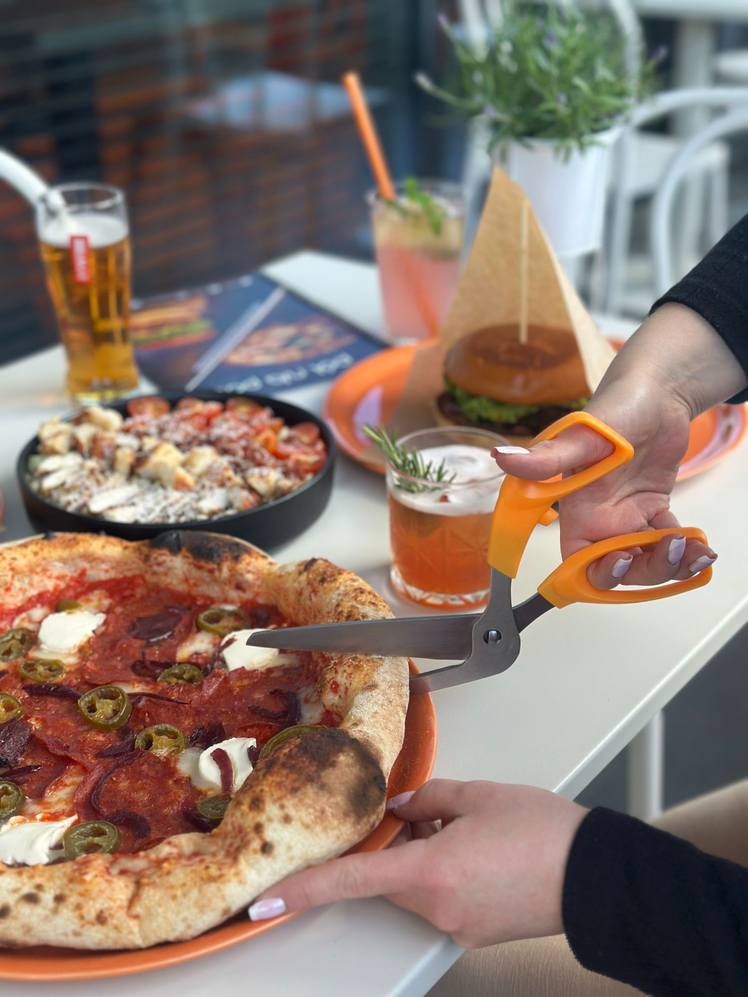 Burger z soczystym kotletem, serem, bekonem i sałatą, podany na tle stylowej restauracji.