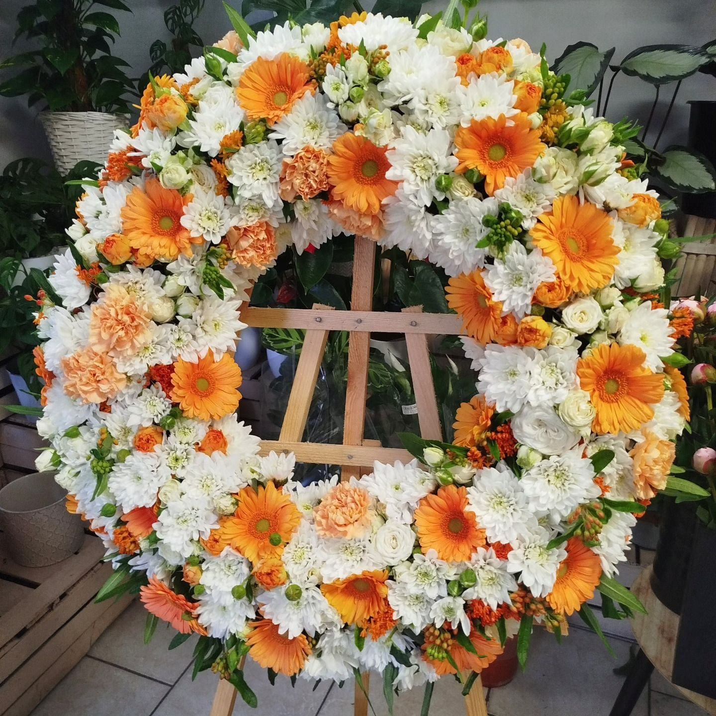 Wieniec na stojaku z gerberów, goździków i margaretek