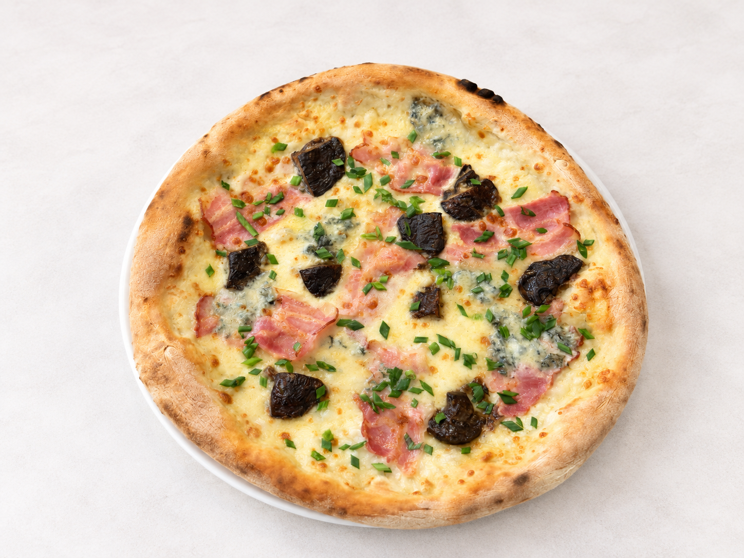 Pizza z serem pleśniowym, bekonem i ziołami na cienkim cieście.