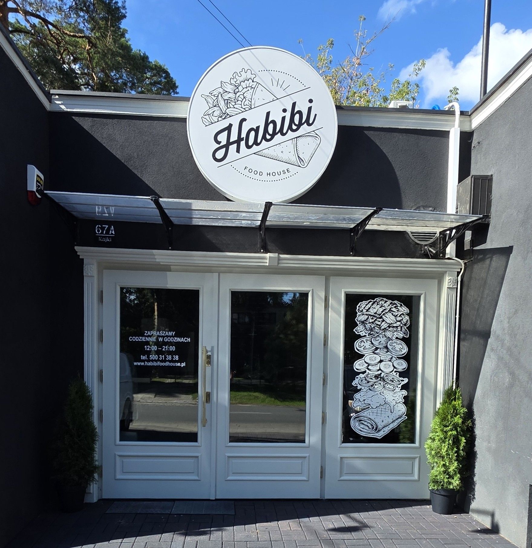 Wejście do restauracji "Habibi Food House" z logo i ozdobami na drzwiach.