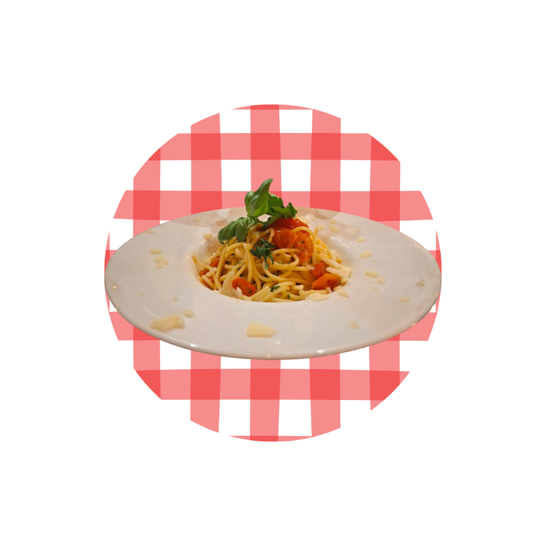 Makaron spaghetti z sosem pomidorowym i ziołami, podany na talerzu na tle czerwonej kratki.