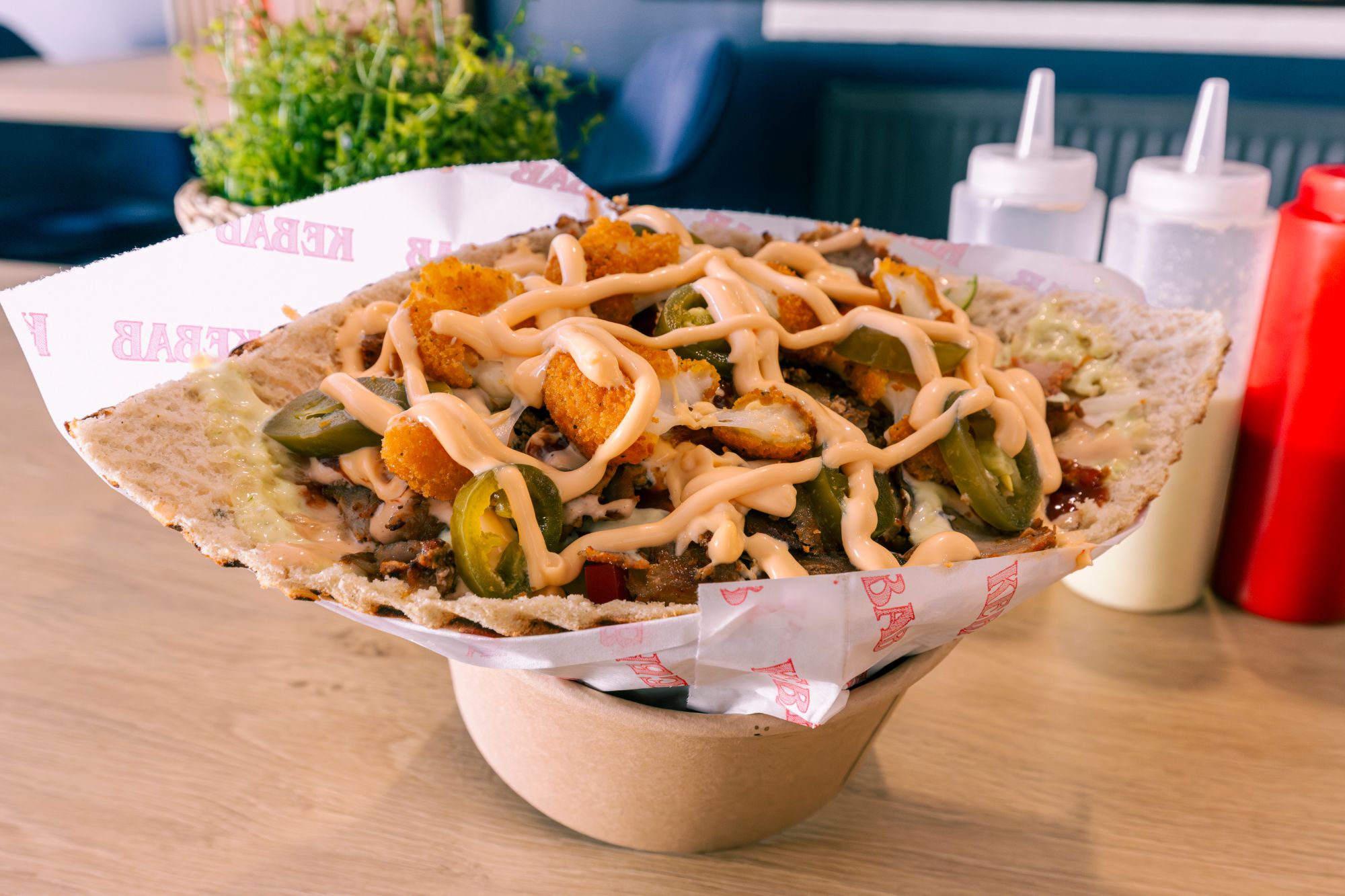 Bowl z nachos, z serem, jalapeños, kurczakiem i sosem, podany na ciepłym, chrupiącym cieście.