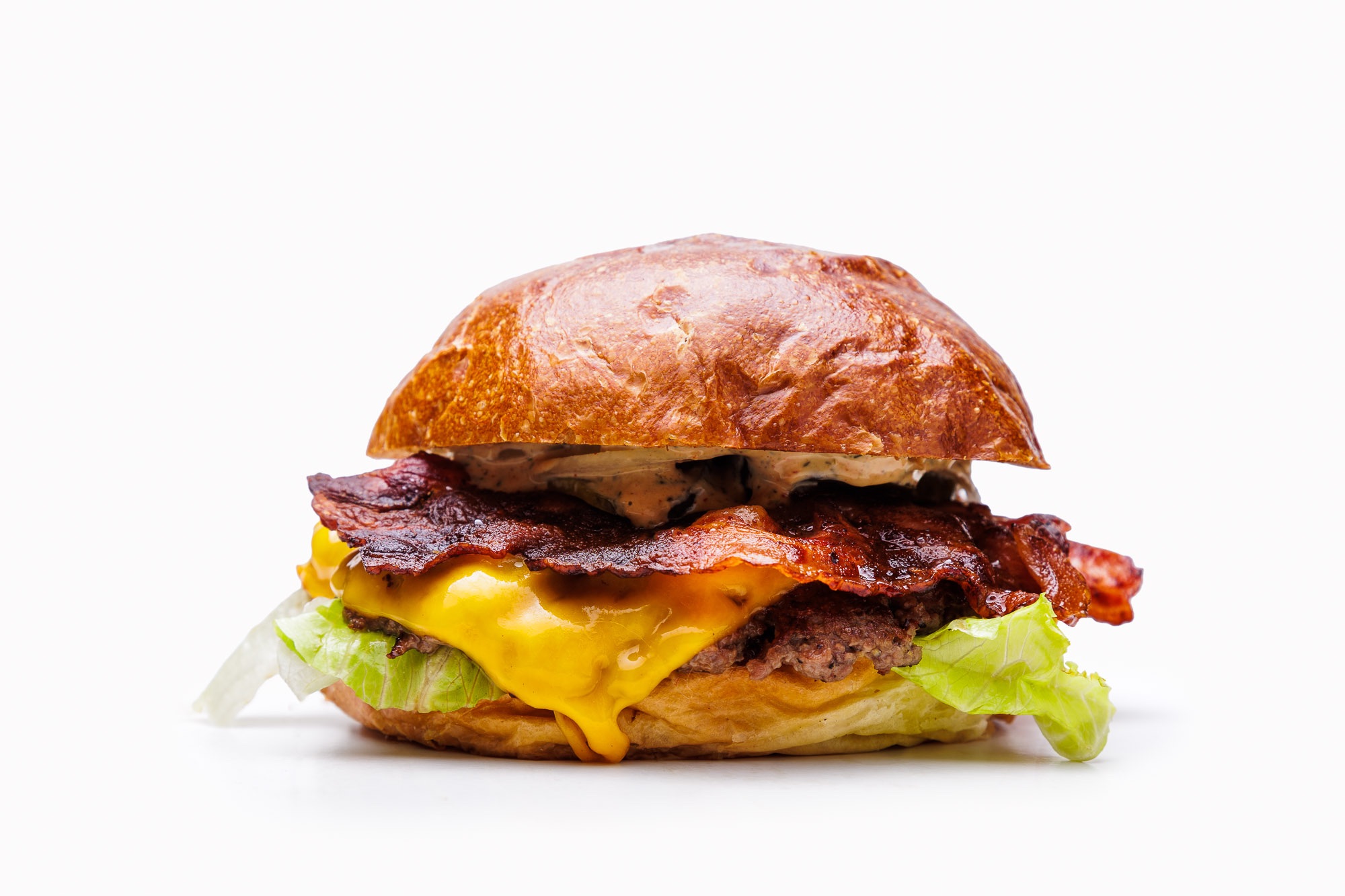 Soczysty hamburger z serem cheddar, bekonem, sałatą na miękkiej bułce.