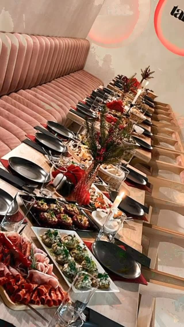 Elegancka kolacja z długim stołem, ozdobiona potrawami i dekoracjami, w przytulnym wnętrzu.