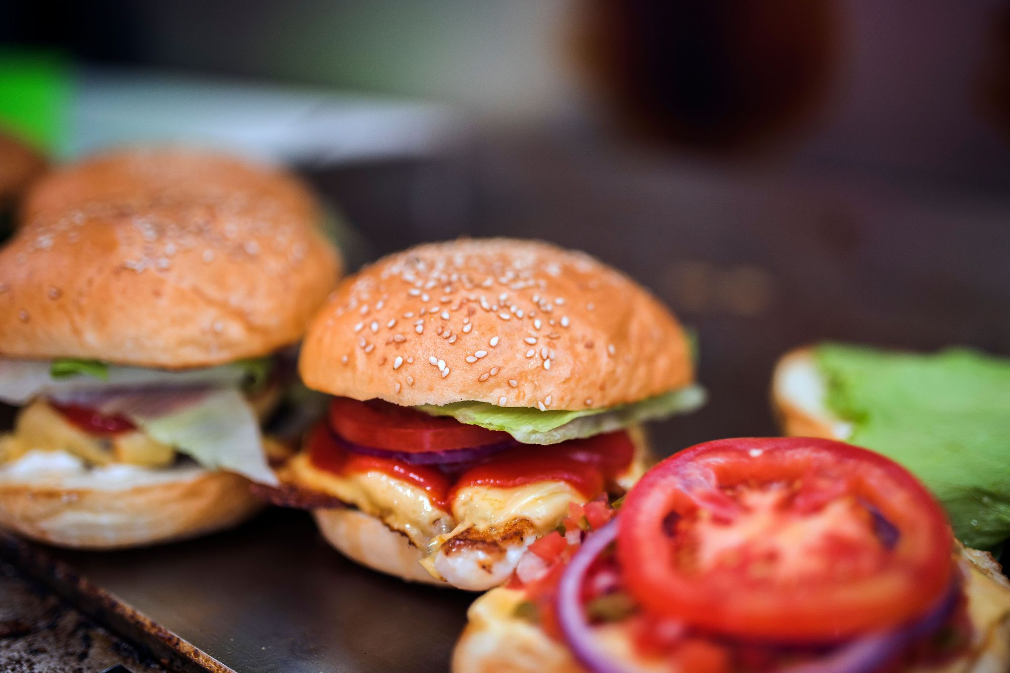 Sześciowarstwowy burger z soczystą wołowiną, świeżymi warzywami i sosem, podany w bułce sezamowej.