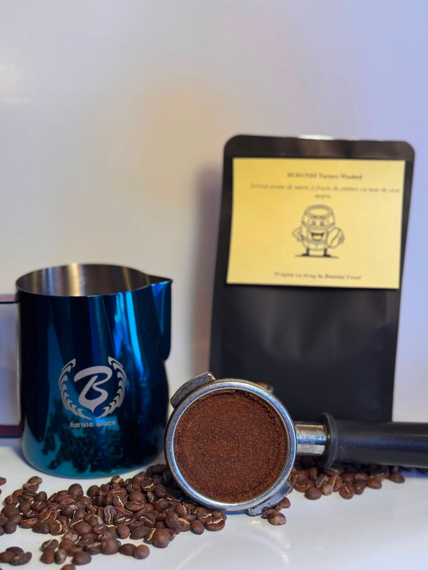 Cafetiere cu cafea măcinată, boabe de cafea și pachet de cafea pe fundal alb.