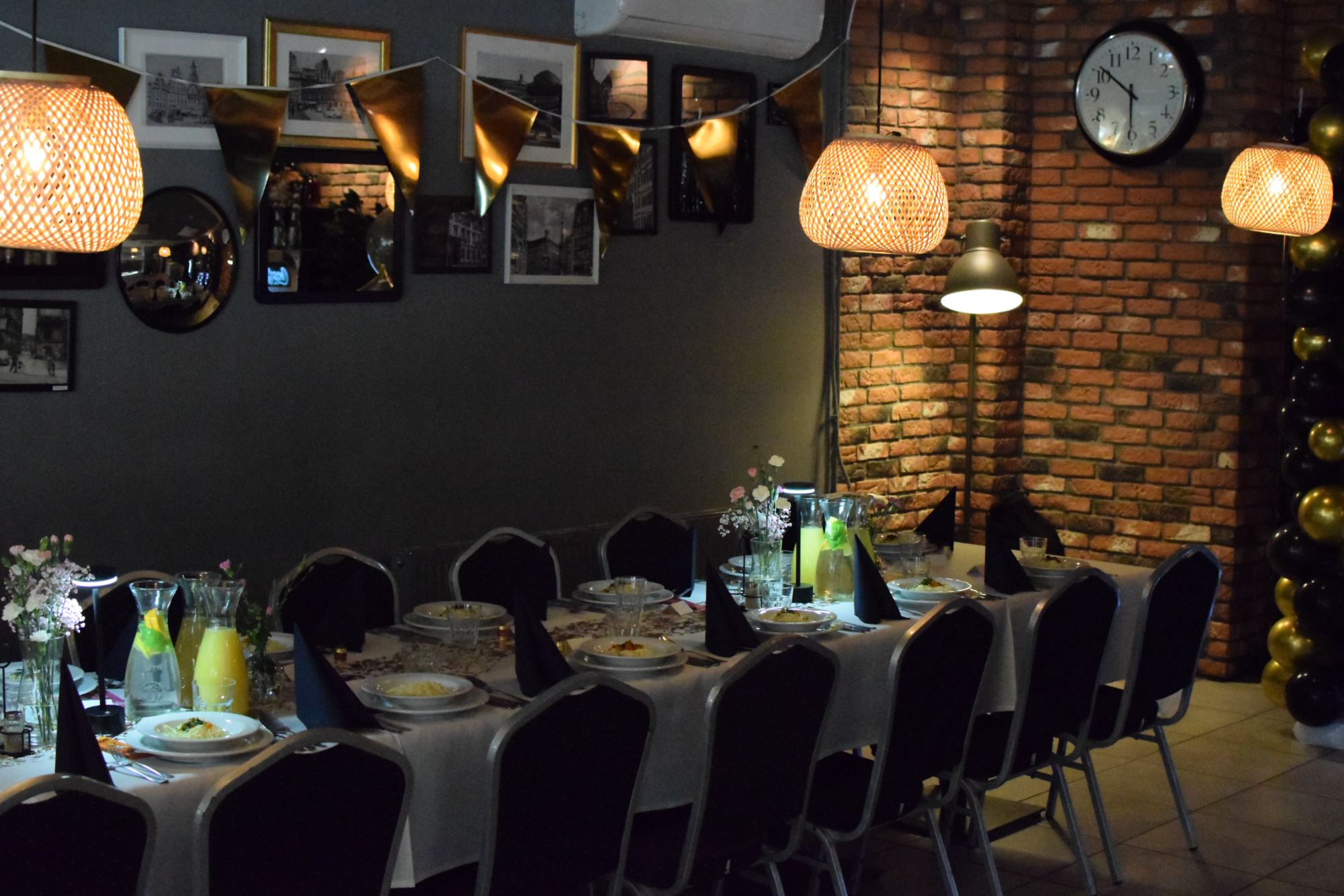 Elegancko udekorowany stół z nakryciami, oswietleniem i dekoracjami w nowoczesnej restauracji.
