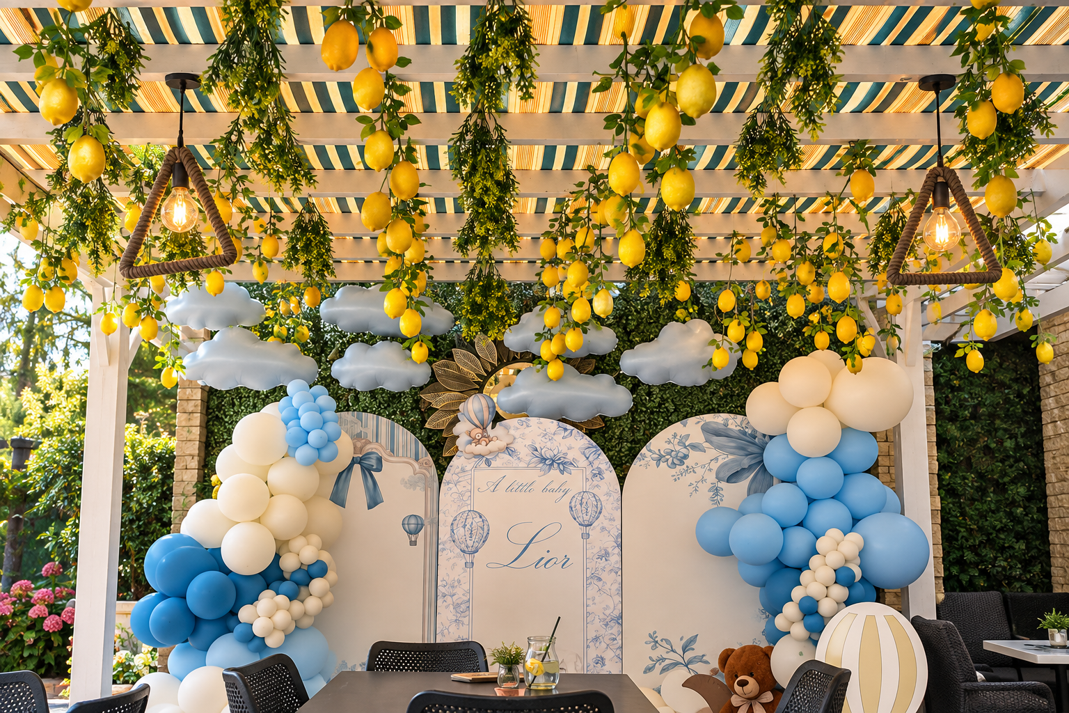 Decor de petrecere cu baloane albastre și albe, citrice suspendate și detalii florale într-un spațiu elegant.