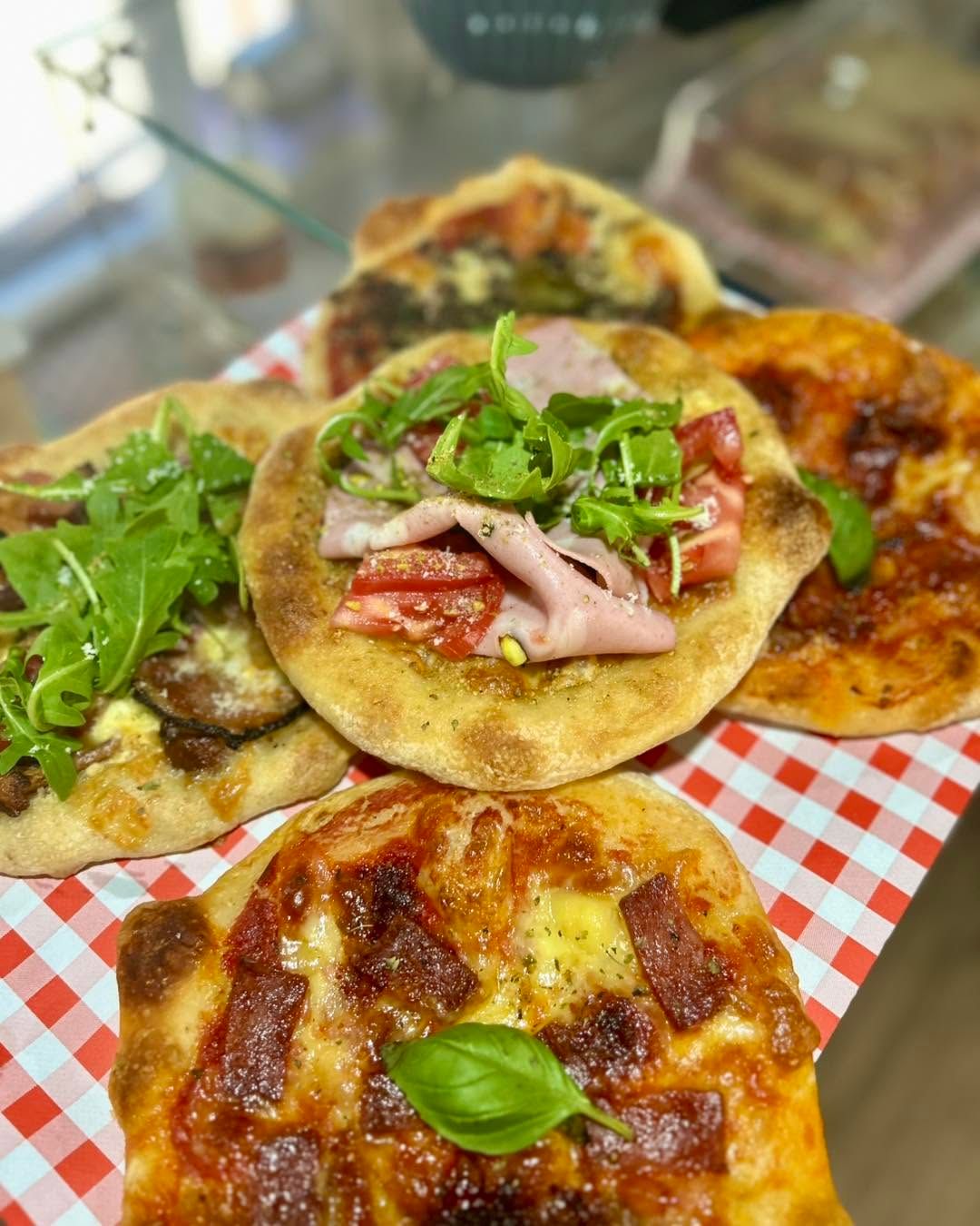 Tradycyjne włoskie pizze na talerzu, różne składniki, świeże zioła, apetyczne i kolorowe.