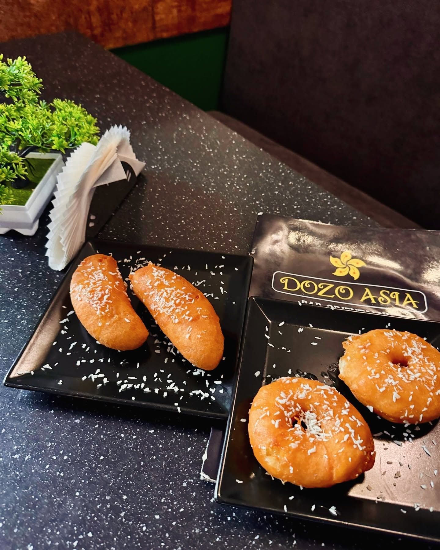Słodkie ciastka na talerzach, posypane wiórkami kokosowymi, w restauracji Dozo Asia.