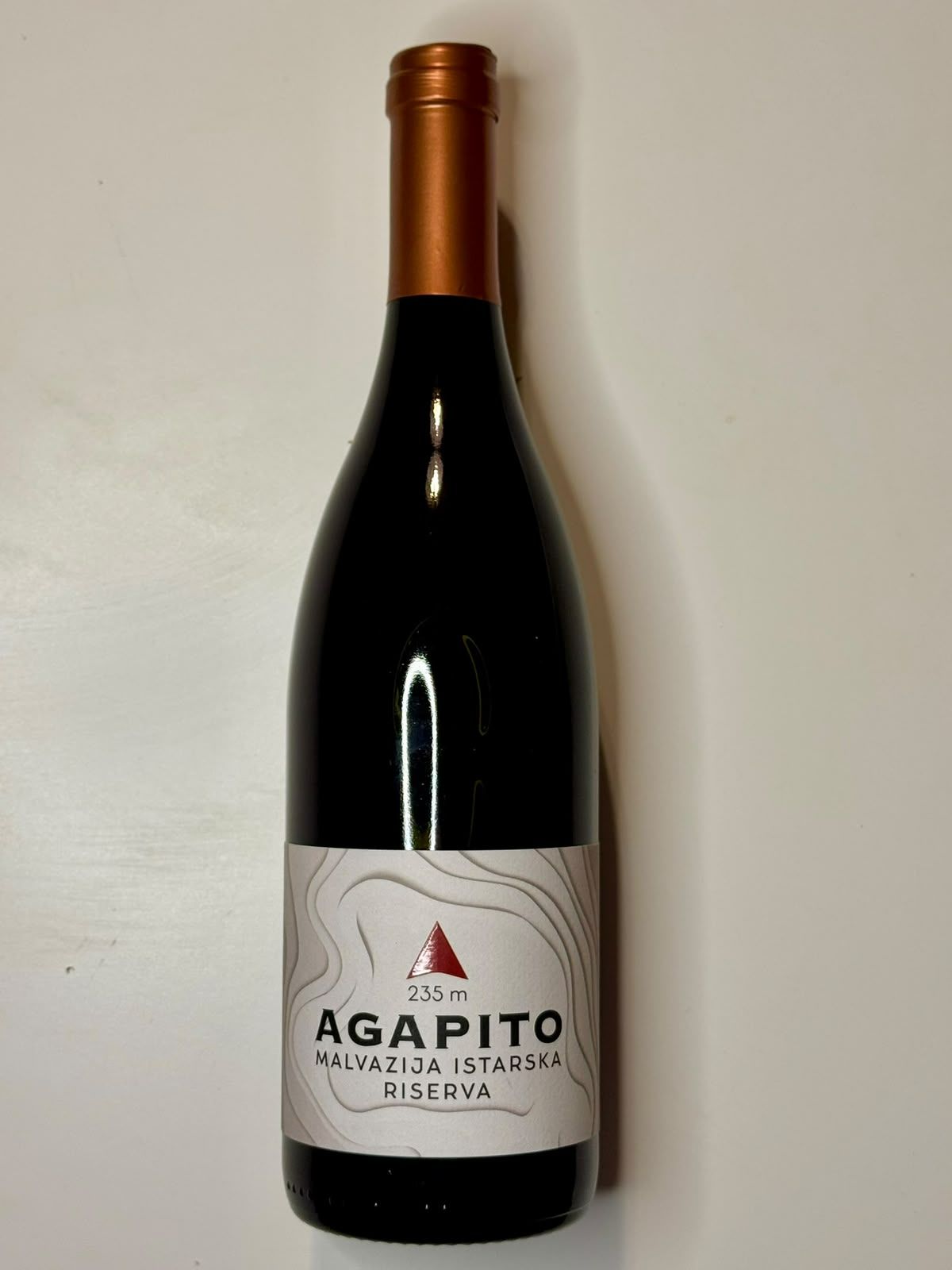 Boca crnog vina Agapito Malvazija Istarska Riserva, oznaka 235 m, s prekrasnim etiketom.