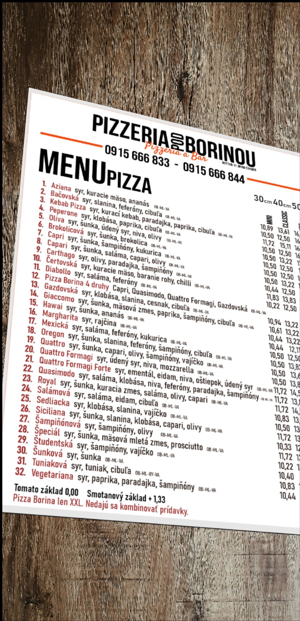Menu pizzerie s rôznymi druhmi pizze a cenami, na drevenom pozadí.