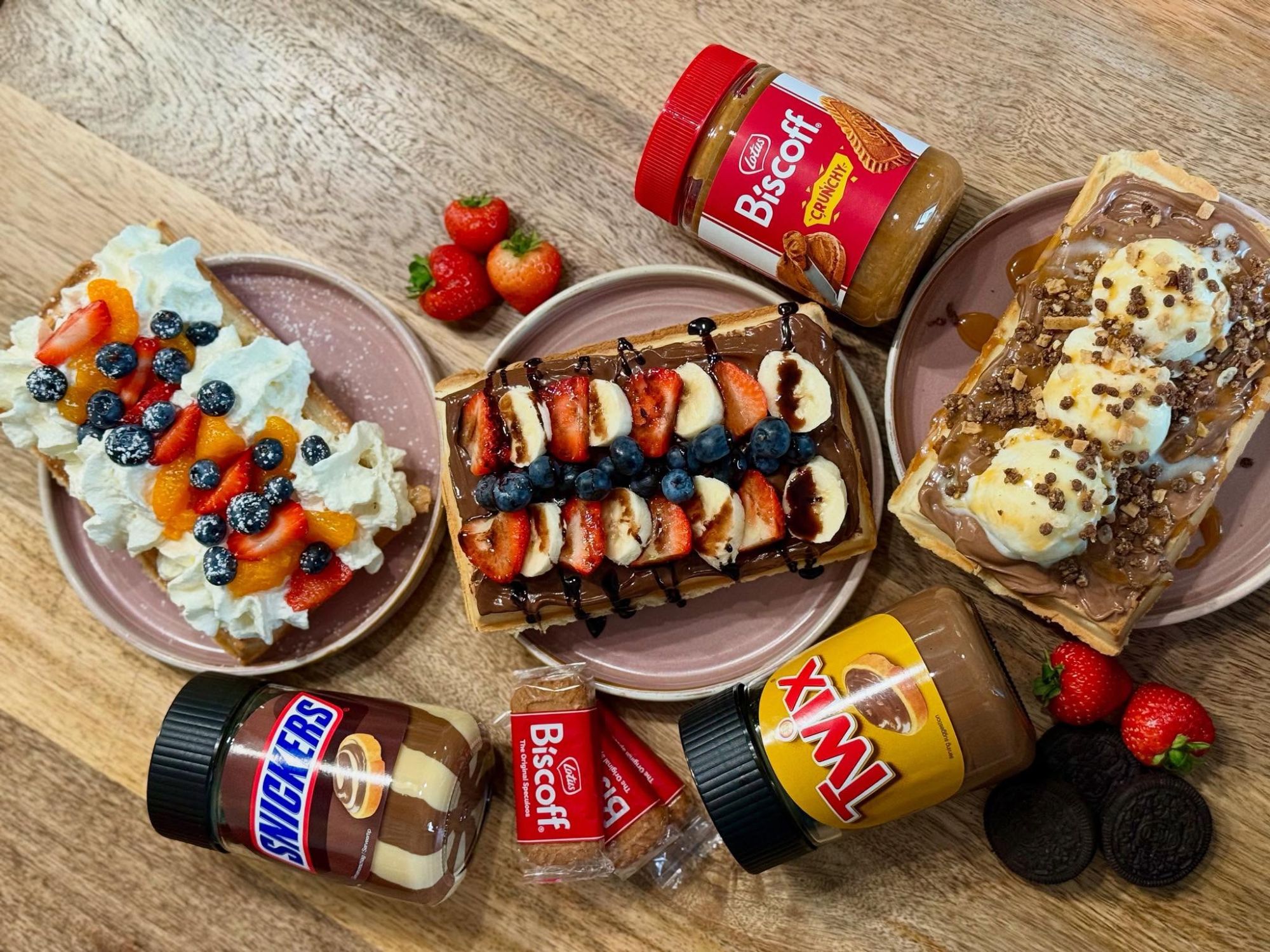 Pyszne gofry z owocami, bitą śmietaną, polewami i smakołykami, takimi jak Biscoff i Snickers.