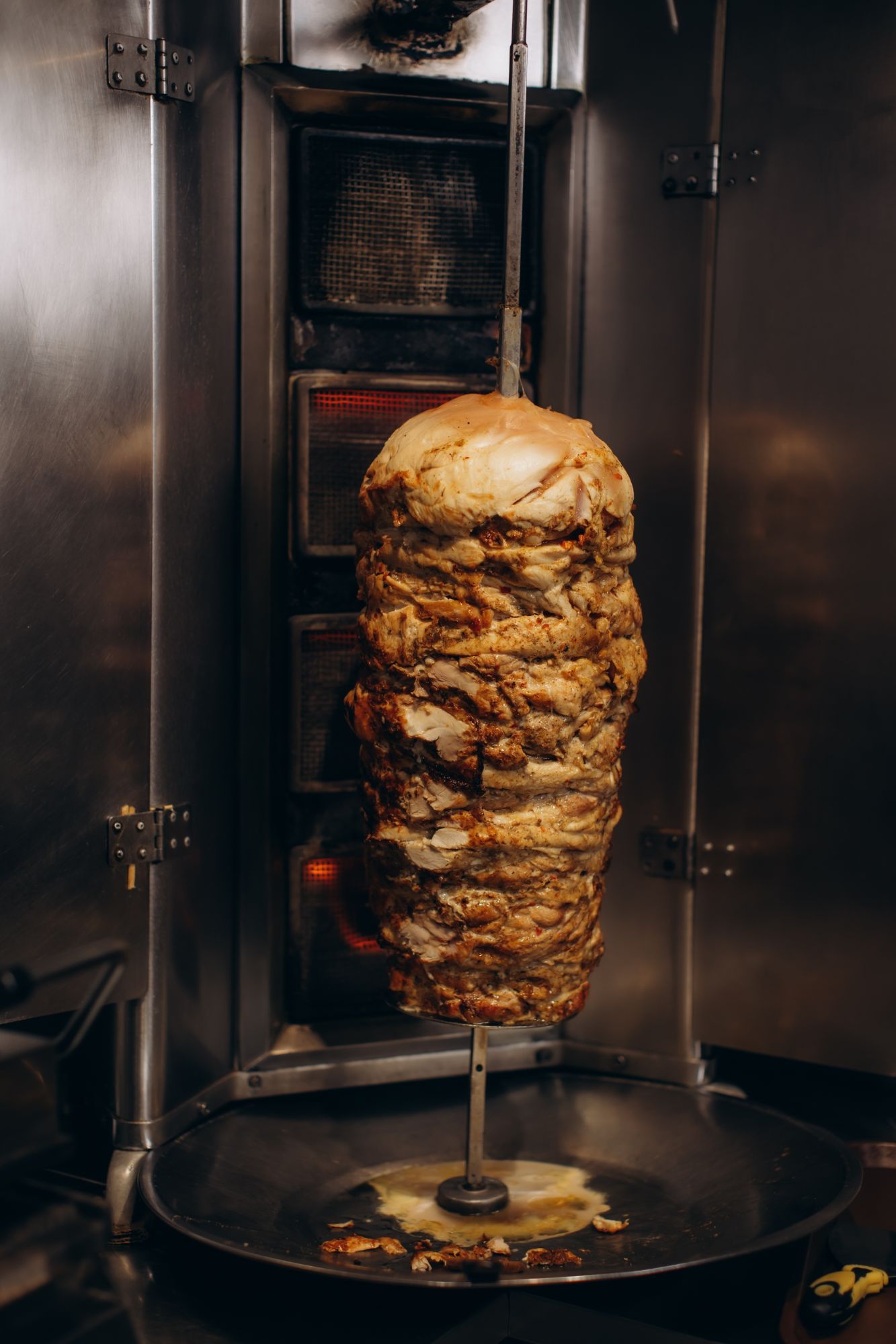 Obracający się kebab w piecu, zrumieniony, na stalowym ruszcie.