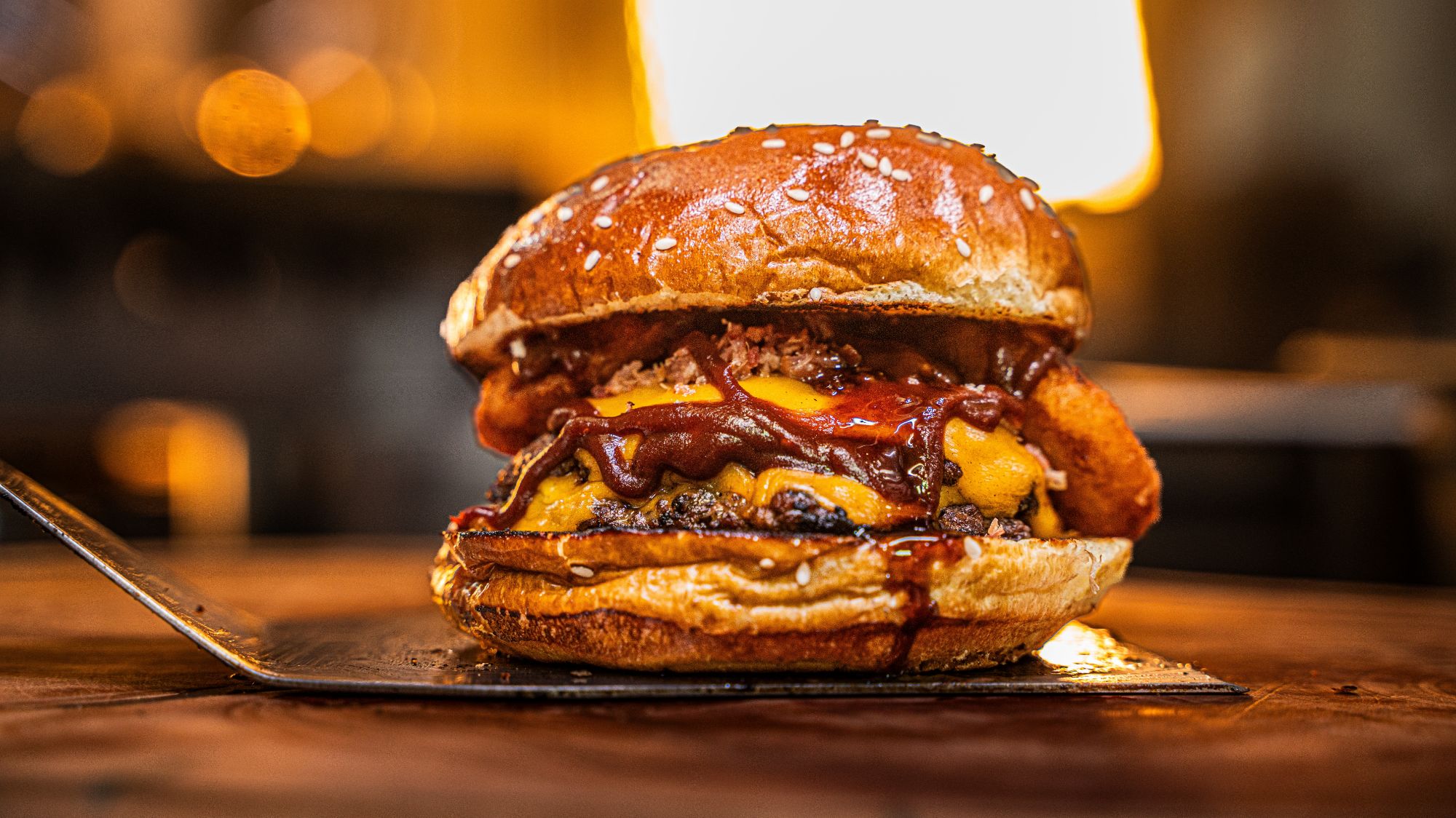 Soczysty burger z serem, bekonem i sosem BBQ w miękkiej bułce z sezamem.