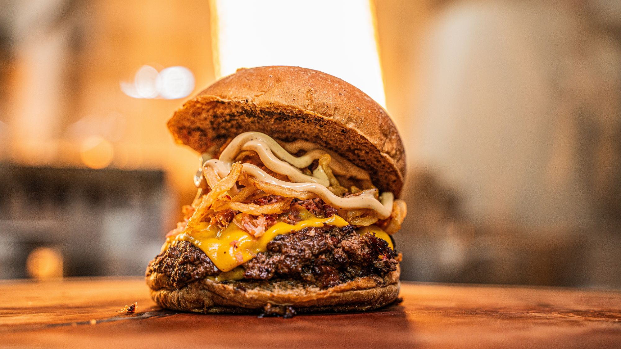 Soczysty burger z serem cheddar, sosem majonezowym i surówką w miękkiej bułce.