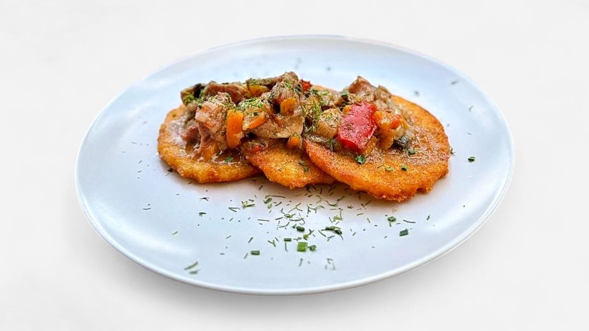 Draniki z smażoną wieprzowiną oraz cebulą